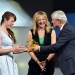 Carolin Schramm ,Gewinnerin des 1. Preises (l.) erhält die Preistrophäea aus der Hand von Andreas Bereczky (ZDF). In der Mitte ie Moderatorin Anja Koebel (MDR).